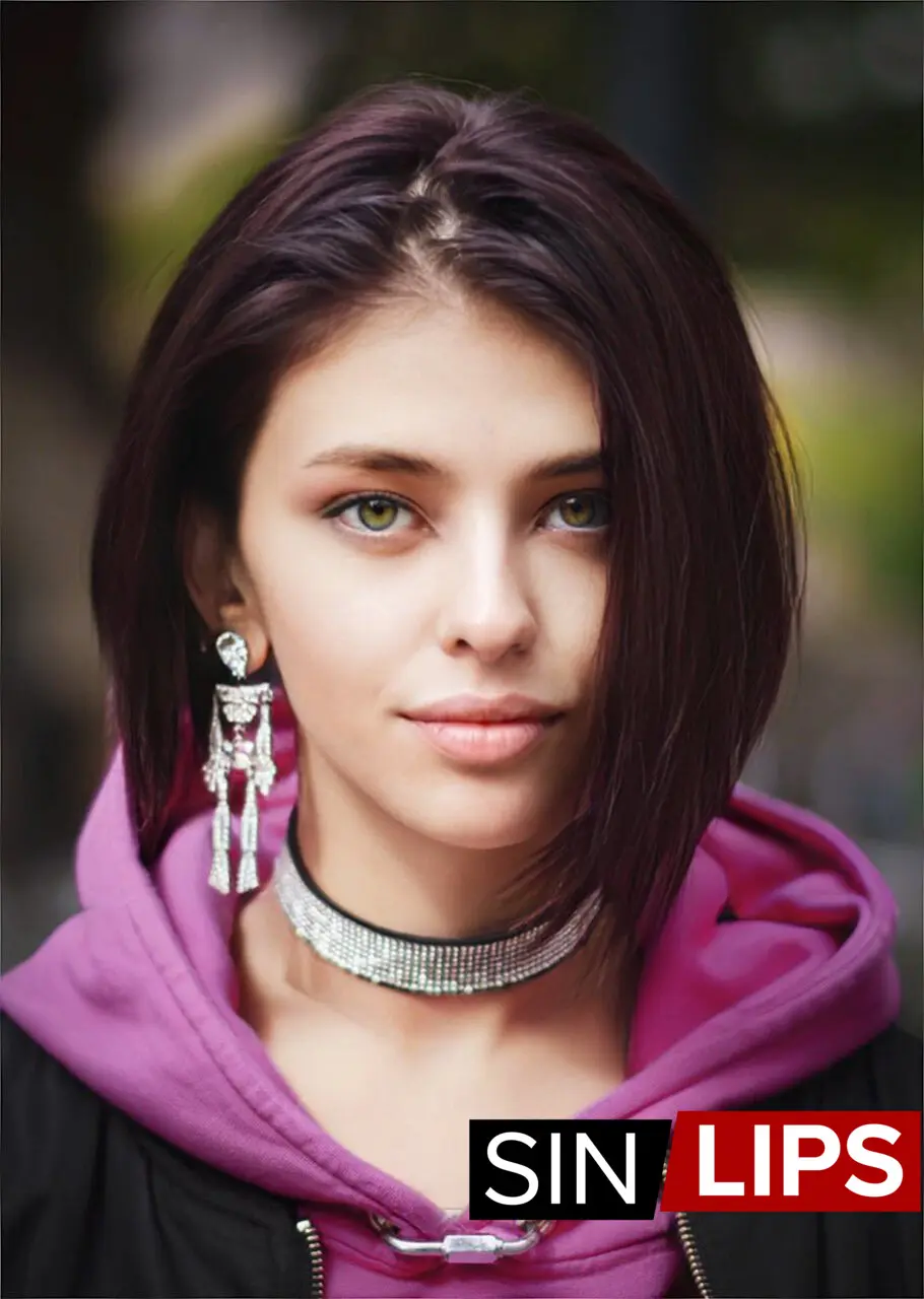 adjika with short hair in a selfie portrait wearing a puple hoodie and long earrings, green eyes