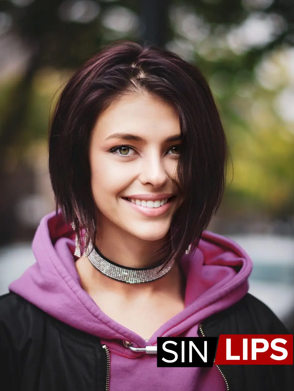 adjika in a selfie photo smiling wearing a purple hoodie and black jacket