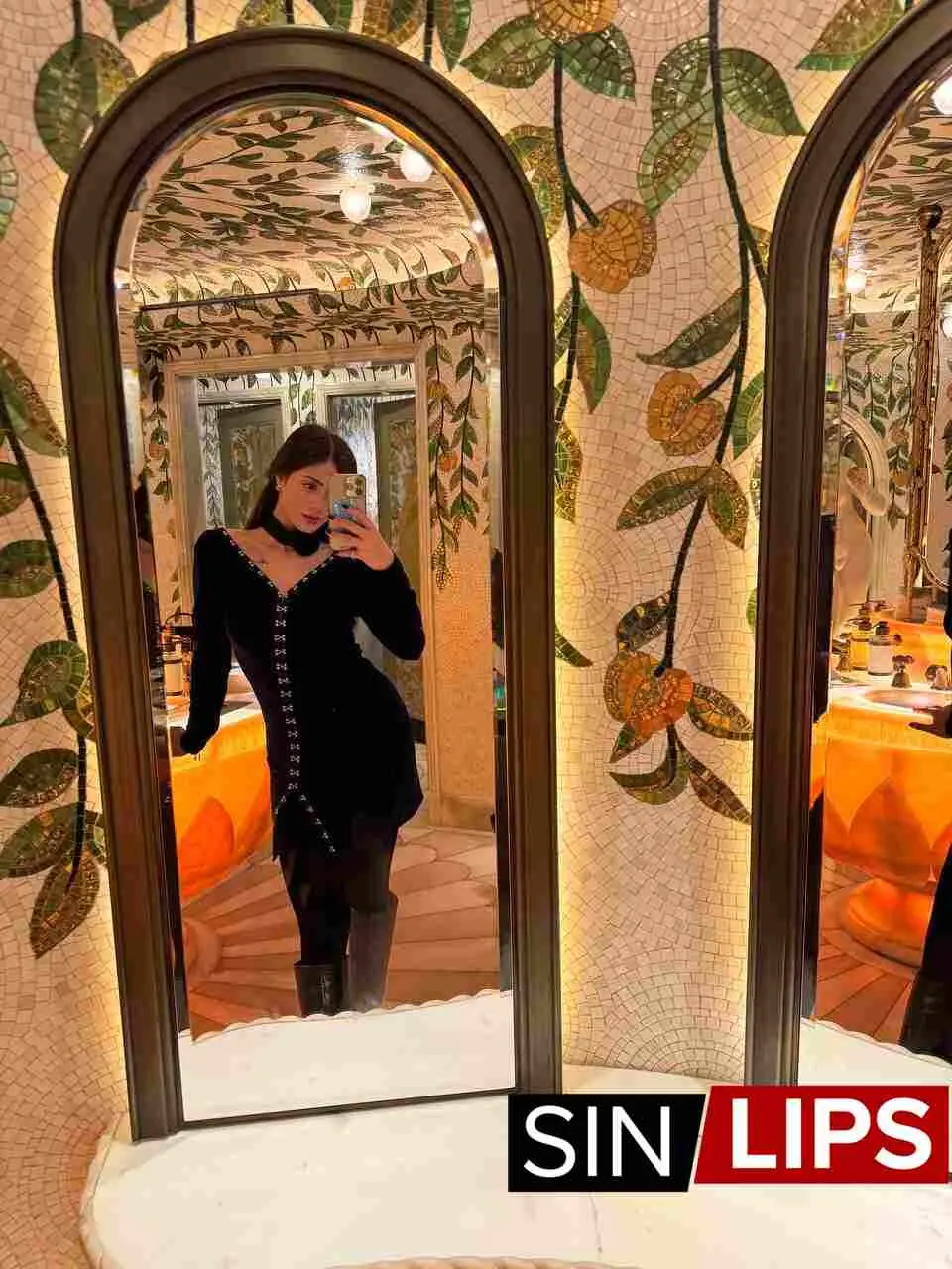 Moire, a Brazilian escort in London wearing a black evening dress taking a selfie in the mirror